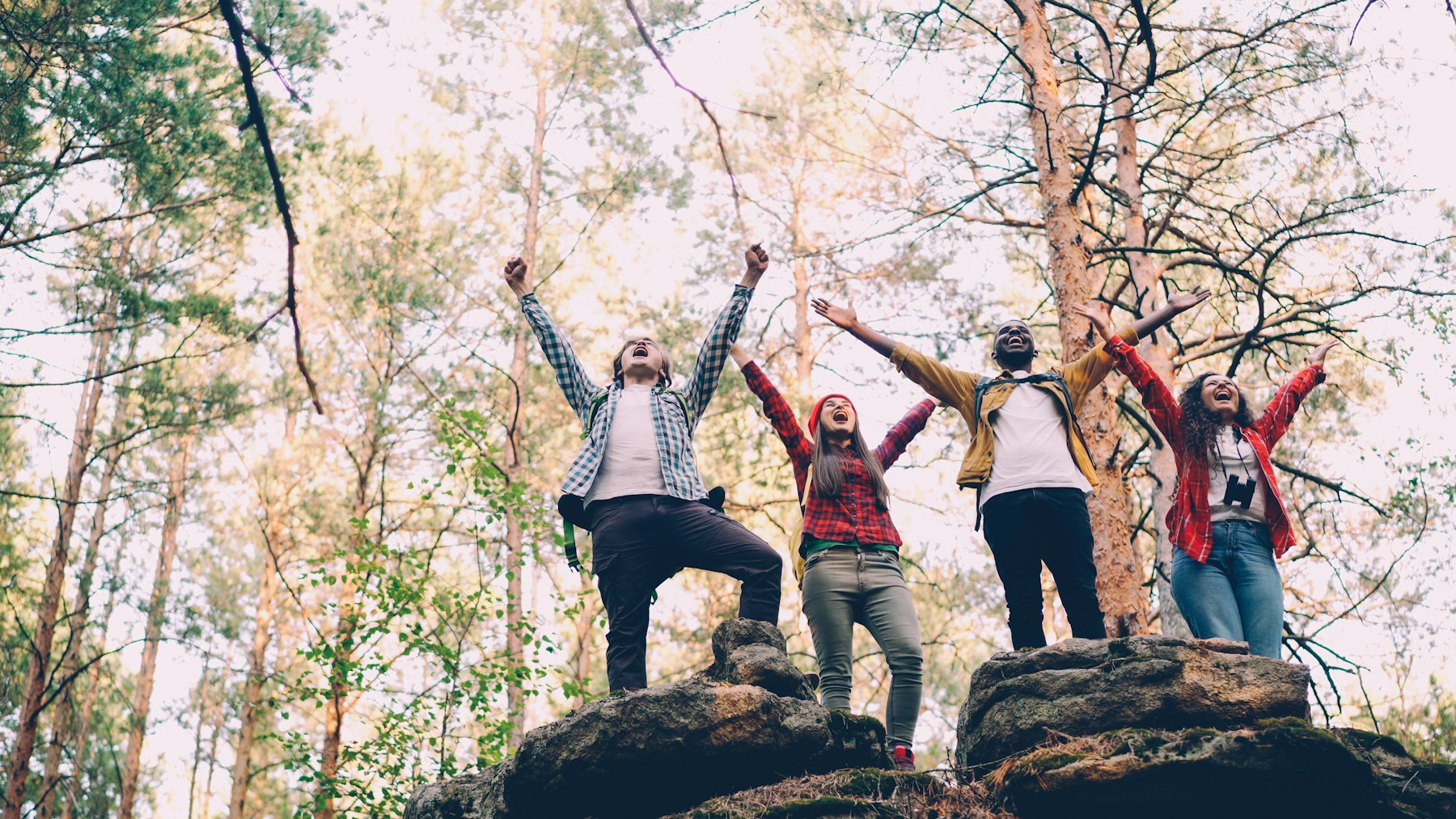 A diverse group of friends celebrating together at the end of a hike